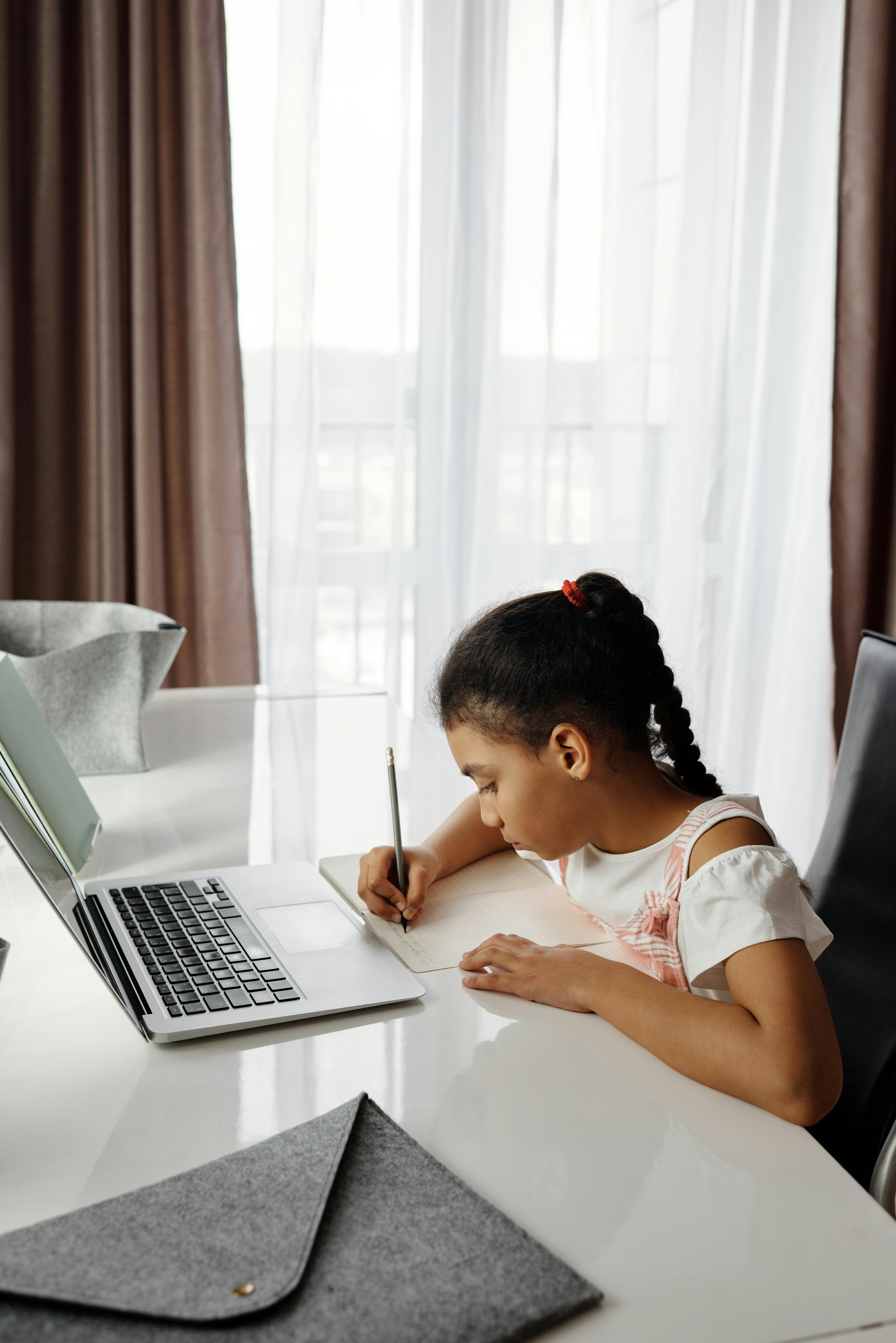 Student using a laptop at a desk during online learning in school